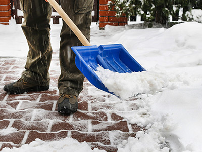 Shoveling the snow to keep the paths cleared for potential buyers
