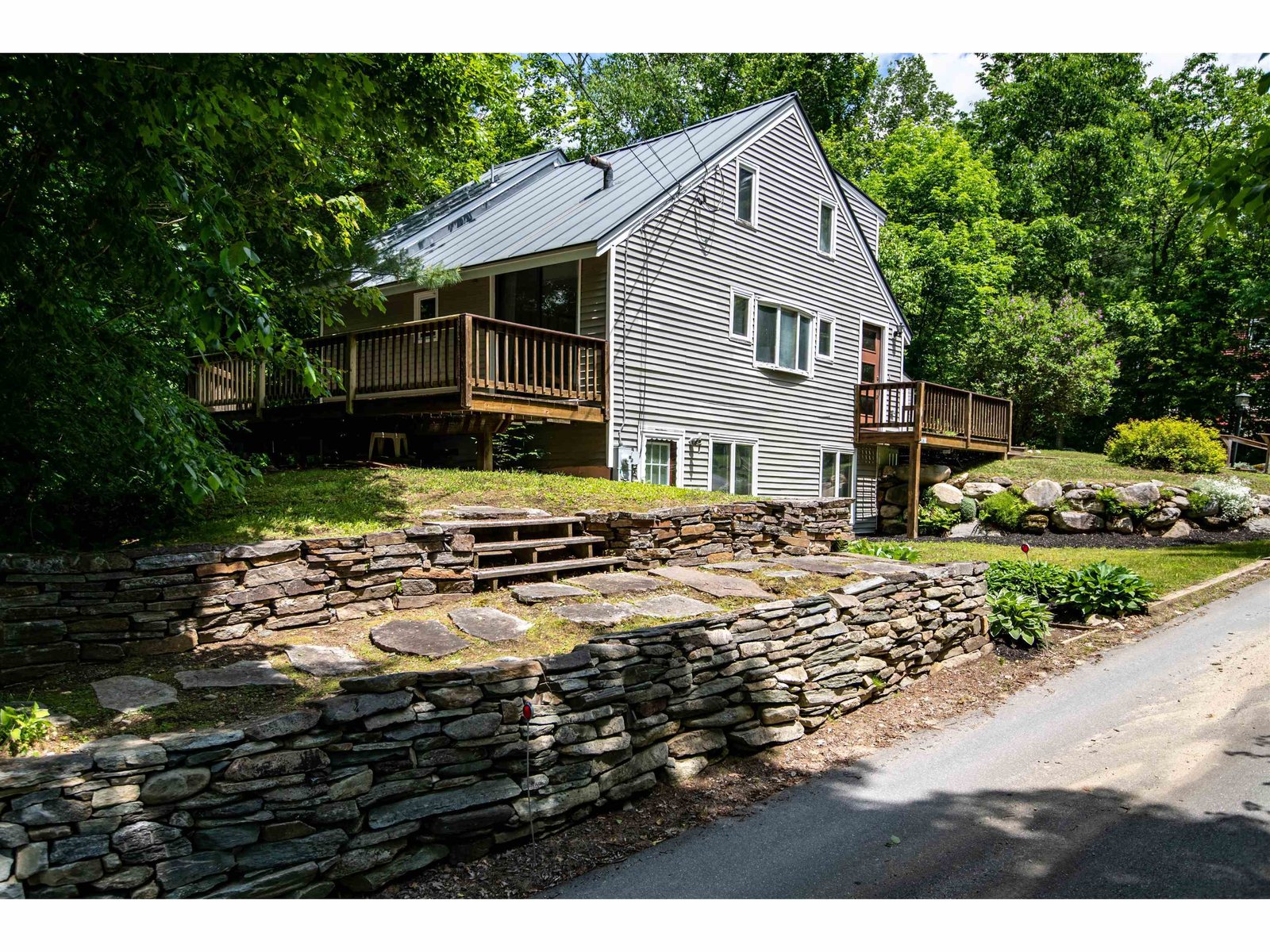Beautiful dry lay stone wall accents this wonderful lakeside home