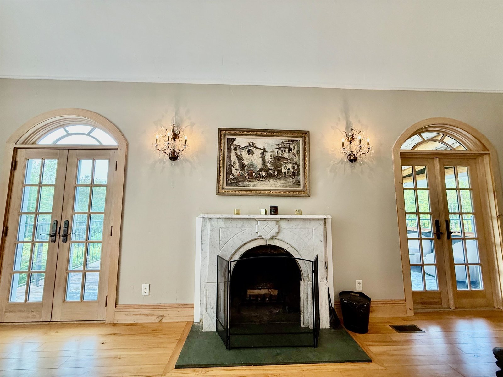 Fireplace flanked by grand, arched doors