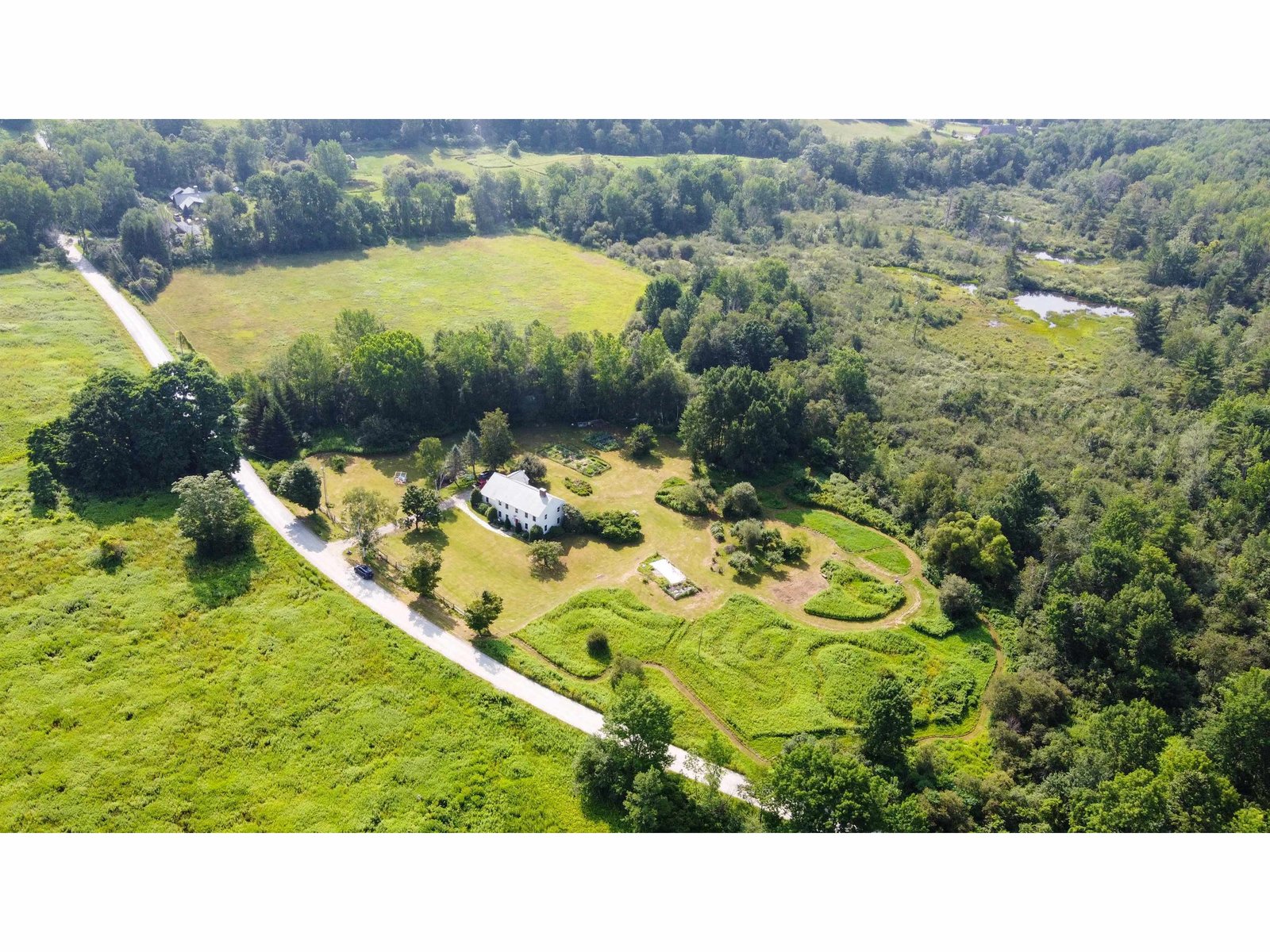 Aerial showing house with adjoimning meadow and protected land across the road