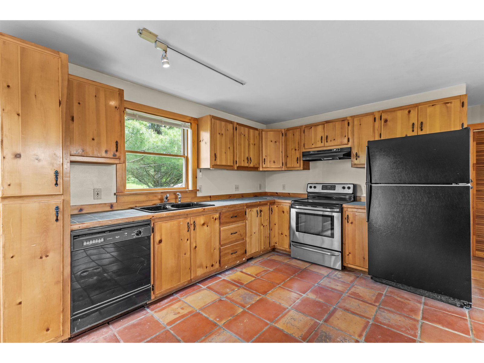 Southwestern tile flooring and pine cabinetry in the kitchen of the accessory.