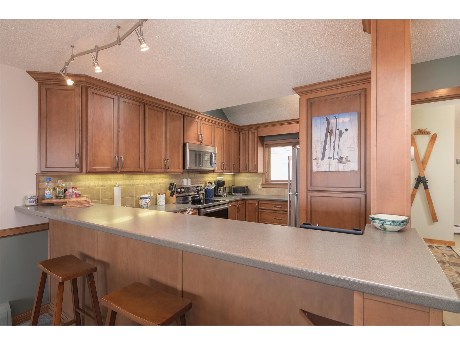 Updated kitchen with wood cabinetry and tilework