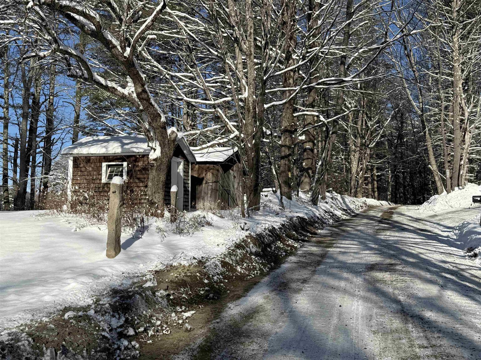 2 small sheds and looking up the road past the house