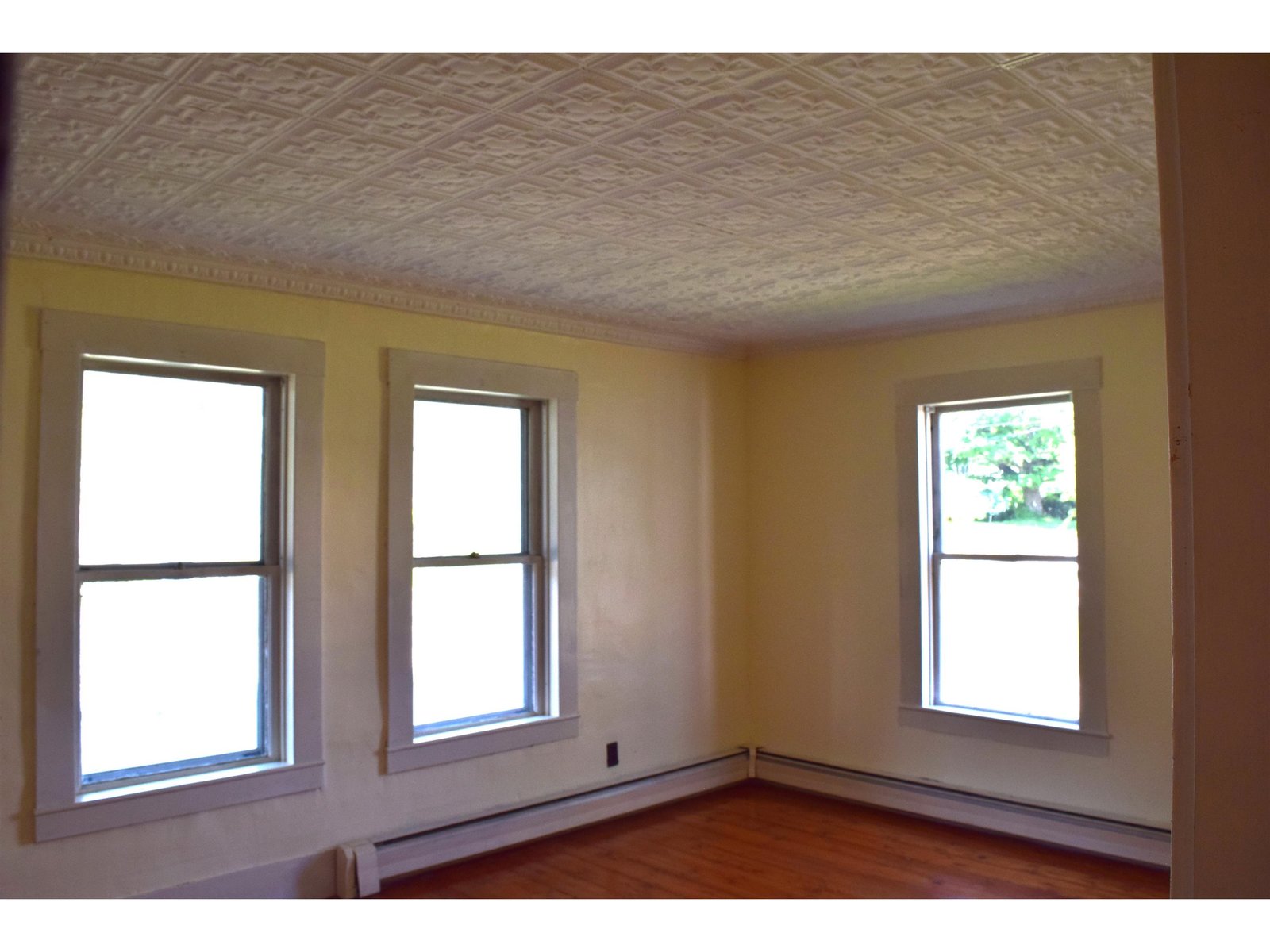 Spacious bedroom with hardwood floors & tin ceilings