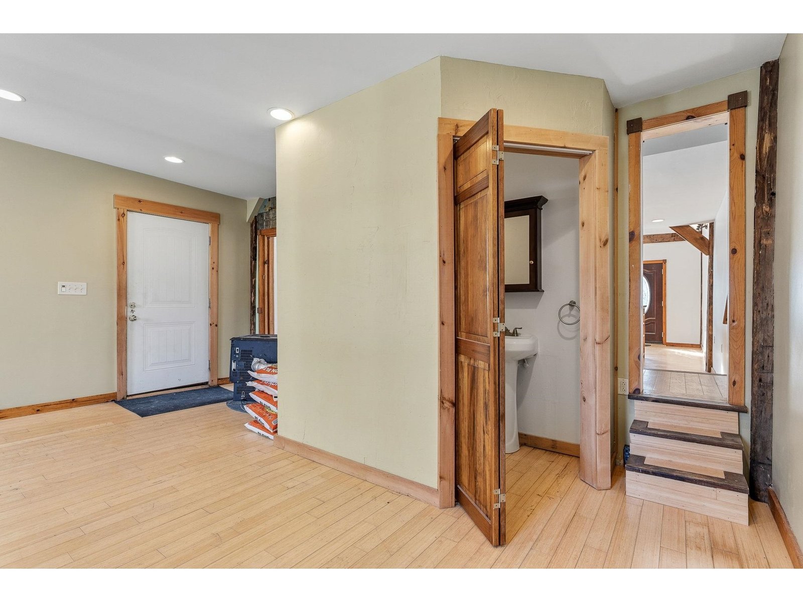 White door leads to side yard, wooden doors lead to half bath
