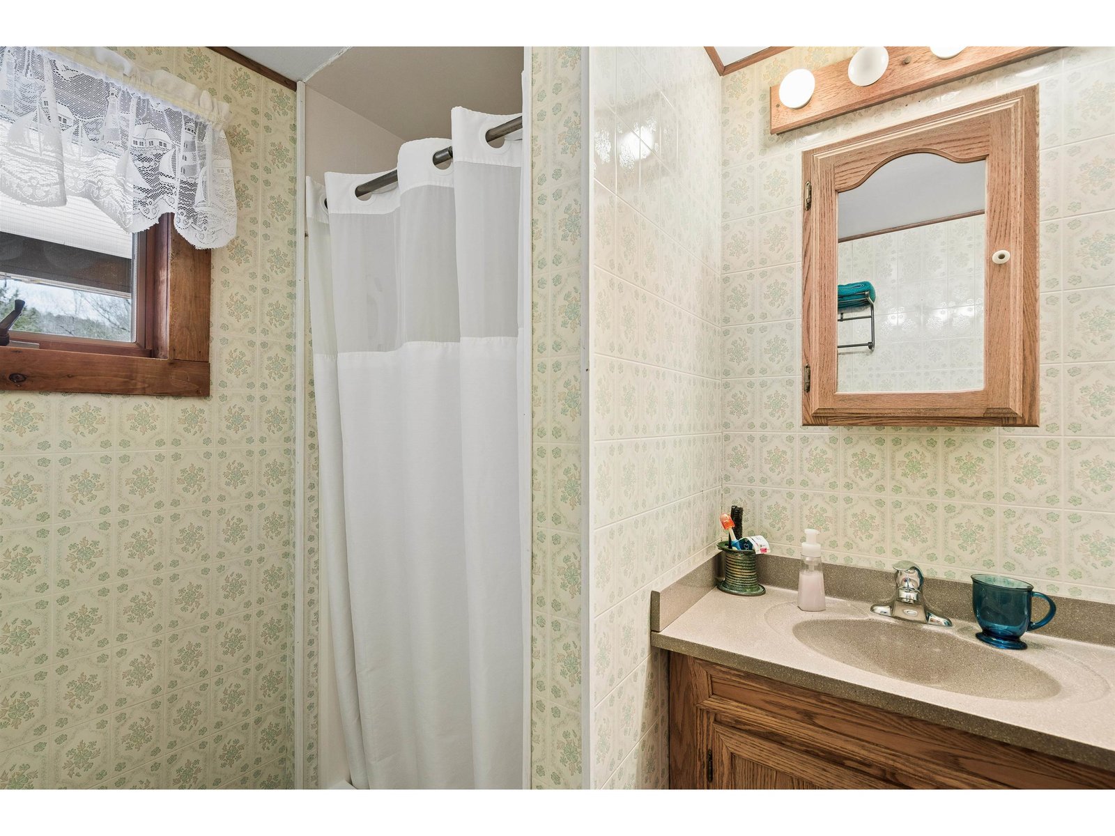 Bathroom in hallway between primary bedroom and kitchen