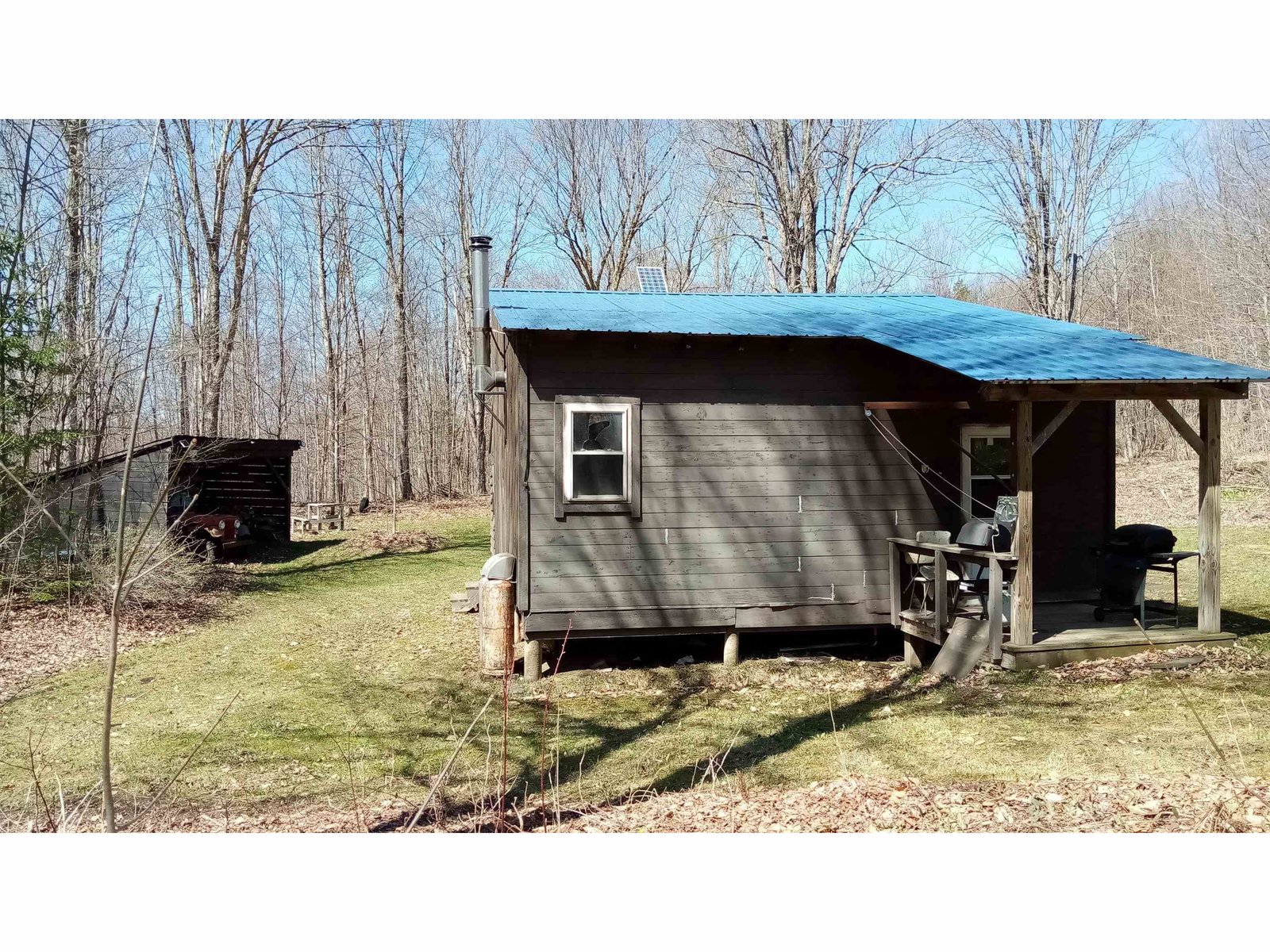 April back of cabin and shed